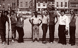 photo of people hanging out in front of a chain-link fence